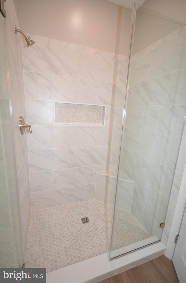 full bathroom with a shower stall and wood finished floors