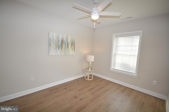 interior space with ceiling fan, wood finished floors, visible vents, and baseboards