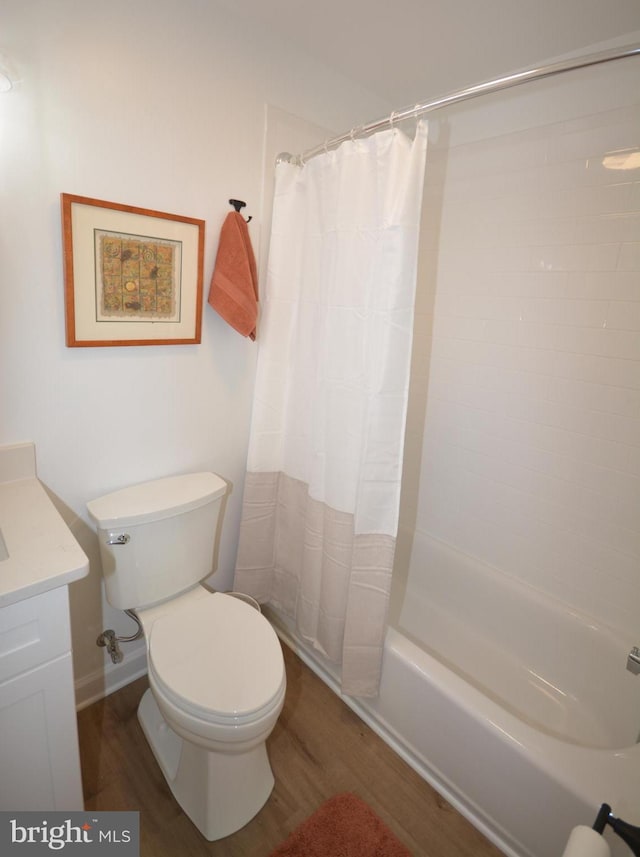 full bathroom with toilet, shower / bath combo with shower curtain, wood finished floors, and vanity