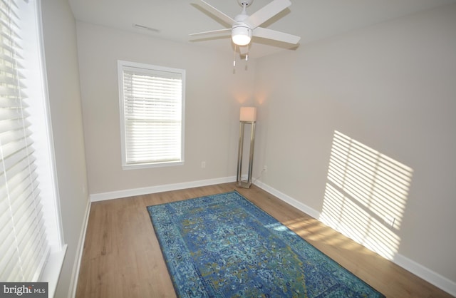 unfurnished room with a ceiling fan, baseboards, and wood finished floors