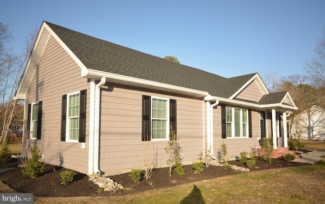 view of side of home featuring roof with shingles