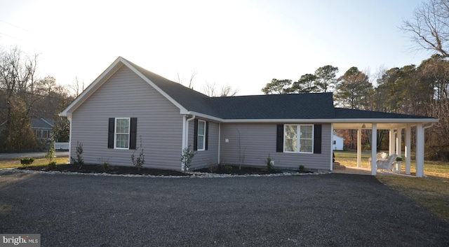 single story home featuring driveway and a carport