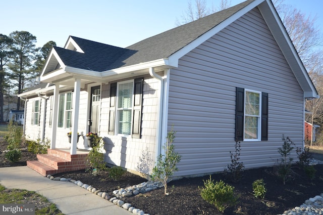 view of side of home with a shingled roof