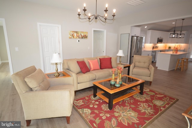 living area with light wood-style floors, recessed lighting, a chandelier, and visible vents