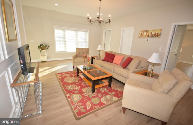 living area featuring light wood-type flooring, baseboards, a chandelier, and recessed lighting