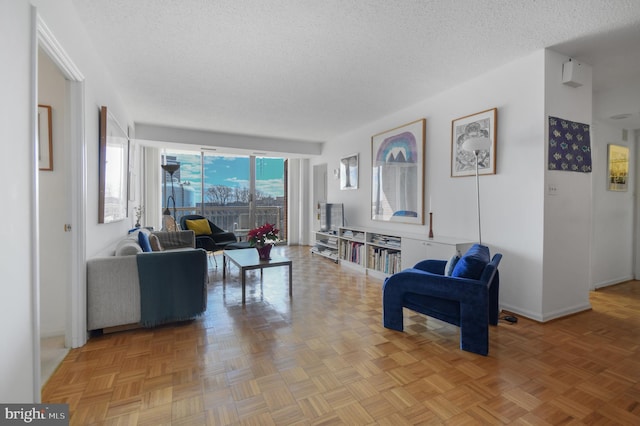 living area with a textured ceiling and baseboards