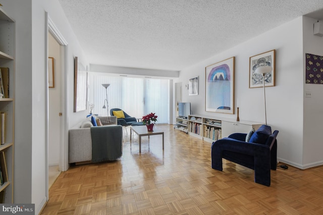 living area featuring baseboards and a textured ceiling