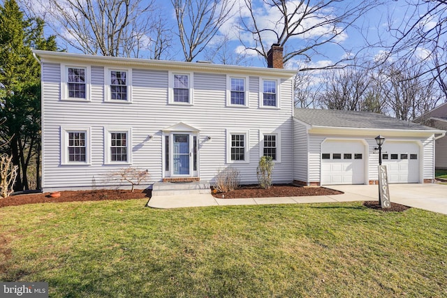 colonial house with a garage, a front yard, concrete driveway, and a chimney