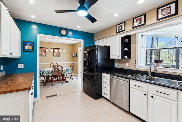 kitchen with a sink, white cabinets, stainless steel dishwasher, and black fridge with ice dispenser