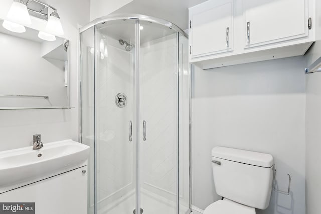 full bath featuring a stall shower, vanity, and toilet