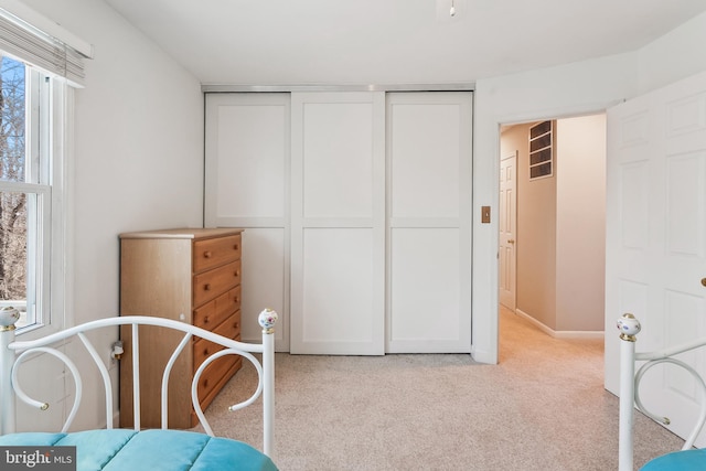 bedroom featuring a closet and light colored carpet