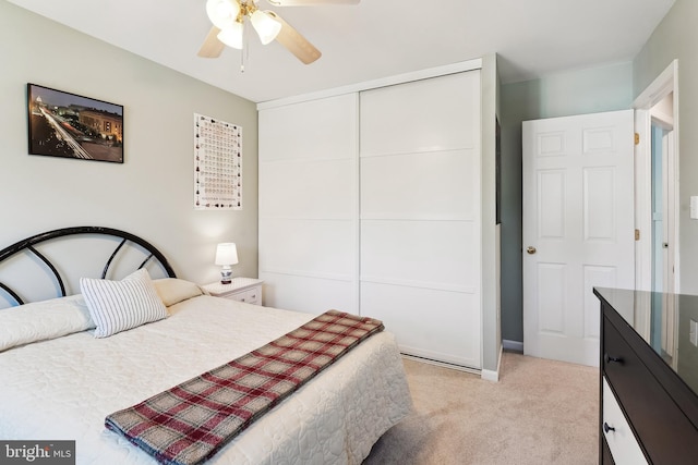 bedroom featuring a closet, a ceiling fan, and light colored carpet