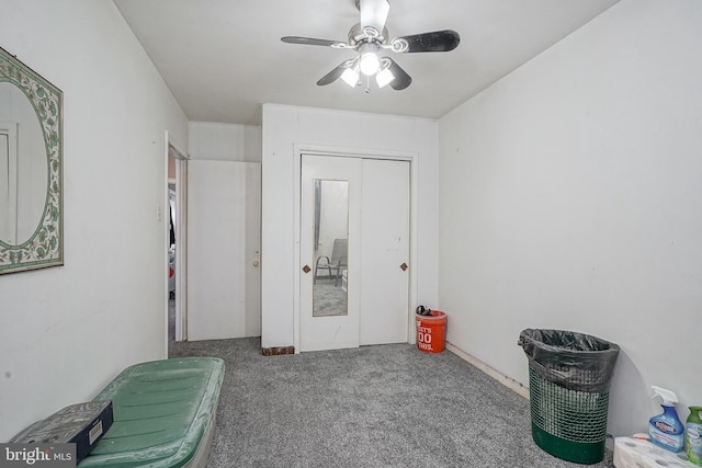 interior space with ceiling fan and carpet