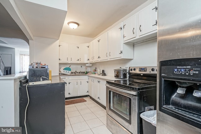 kitchen with light tile patterned floors, electric range, a sink, refrigerator with ice dispenser, and white cabinetry