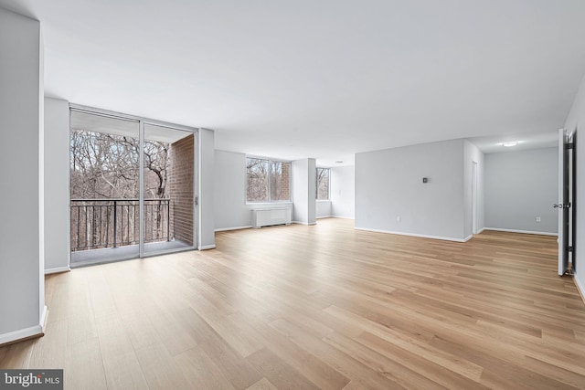 unfurnished living room featuring light wood-style flooring and baseboards