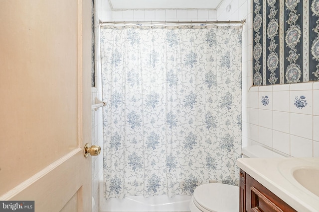 bathroom with toilet, shower / bath combo, vanity, and tile walls