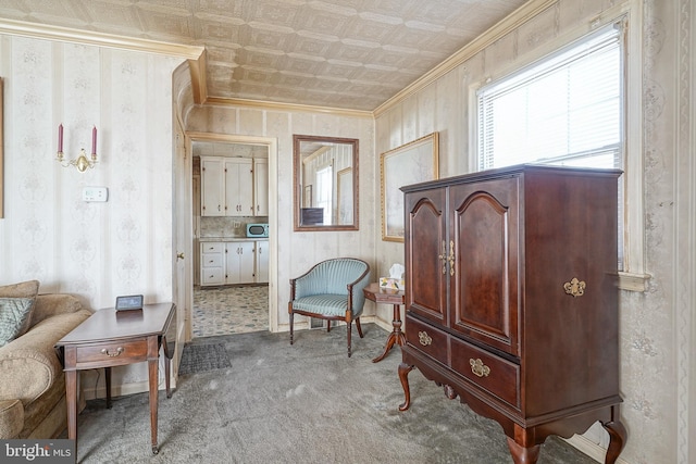 sitting room featuring wallpapered walls, an ornate ceiling, and crown molding