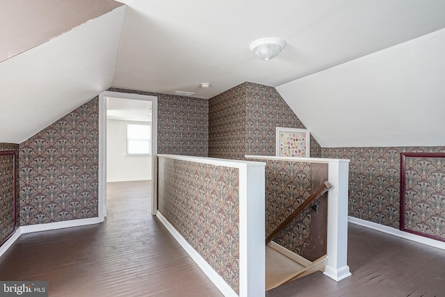 bonus room featuring baseboards, vaulted ceiling, wood finished floors, and wallpapered walls