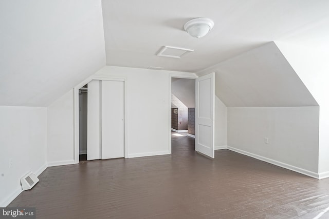 additional living space with attic access, wood finished floors, visible vents, and baseboards