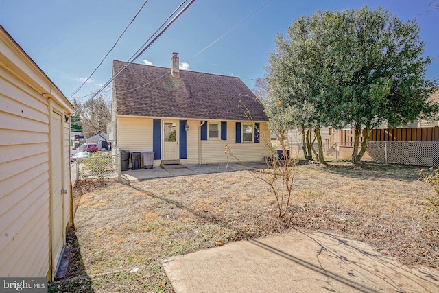 rear view of house featuring a fenced backyard, roof with shingles, and a patio