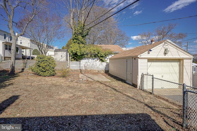 exterior space with a garage, fence, and an outbuilding