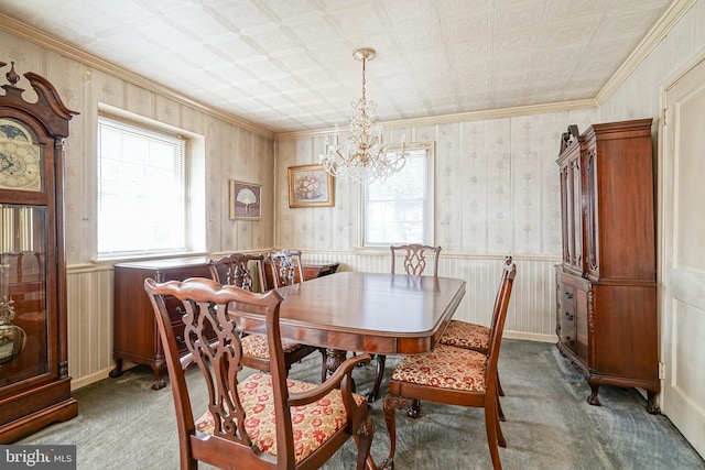 dining area featuring carpet, a healthy amount of sunlight, a wainscoted wall, and wallpapered walls