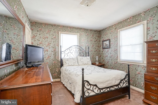 carpeted bedroom featuring wallpapered walls and baseboards