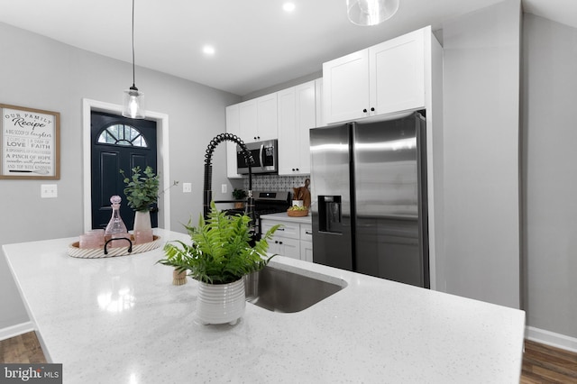 kitchen featuring dark wood-style floors, white cabinetry, stainless steel appliances, and decorative backsplash