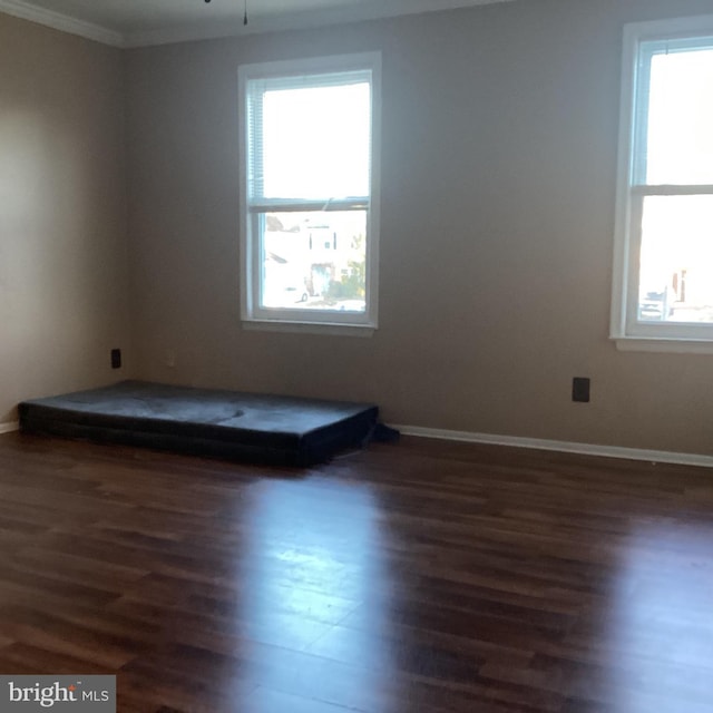 empty room featuring wood finished floors, a ceiling fan, and baseboards