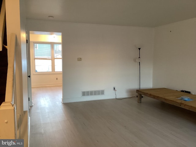 spare room featuring baseboards, visible vents, and wood finished floors