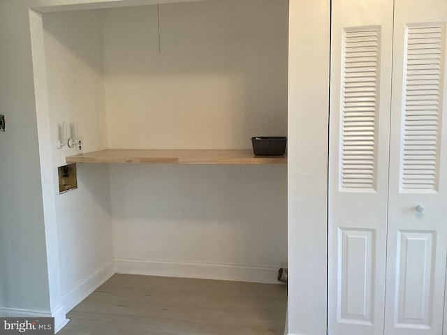 clothes washing area featuring hookup for a washing machine, laundry area, baseboards, and wood finished floors