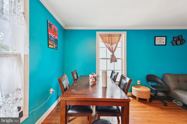 dining room with baseboards, hardwood / wood-style flooring, and ornamental molding