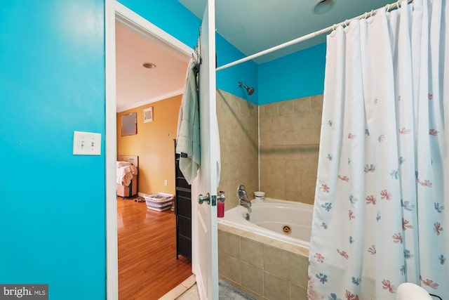 full bath featuring tiled shower / bath combo, crown molding, baseboards, and wood finished floors