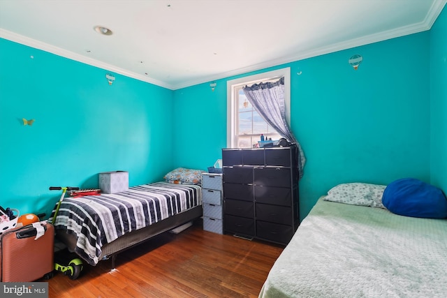 bedroom featuring crown molding and wood finished floors