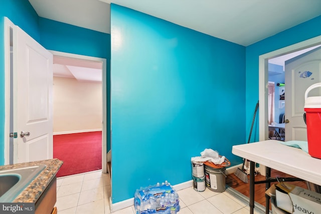 bathroom featuring baseboards, a sink, and tile patterned floors