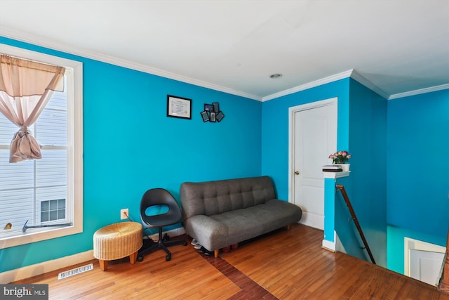 living area featuring crown molding, an upstairs landing, wood finished floors, baseboards, and visible vents