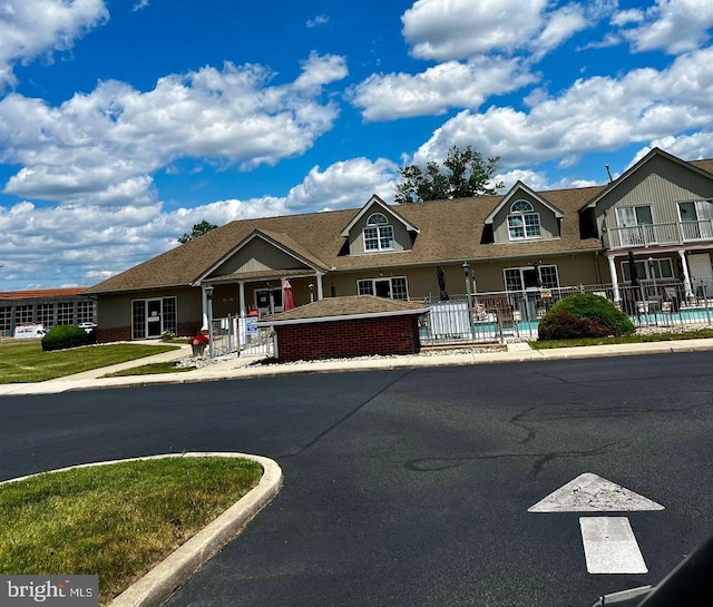 townhome / multi-family property featuring fence, an outdoor pool, and brick siding