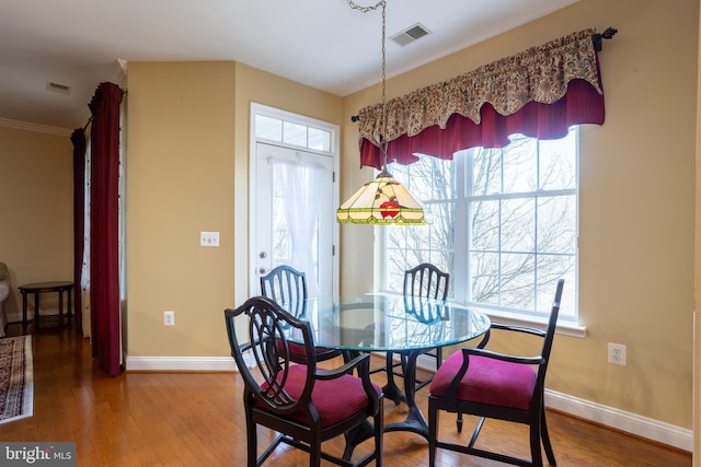 dining area featuring wood finished floors, visible vents, and a healthy amount of sunlight