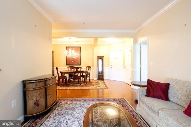 living room featuring ornamental molding, a chandelier, and wood finished floors