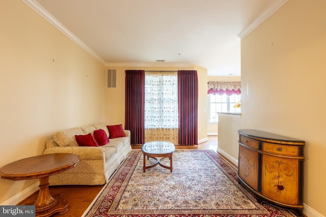 living area featuring ornamental molding, visible vents, baseboards, and wood finished floors