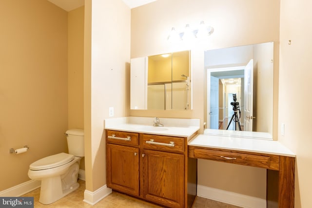 bathroom with toilet, tile patterned flooring, baseboards, and vanity