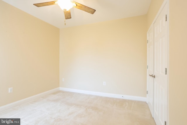 unfurnished bedroom featuring a ceiling fan, a closet, light colored carpet, and baseboards