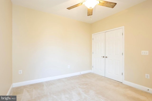 unfurnished bedroom with carpet floors, ceiling fan, baseboards, and a closet