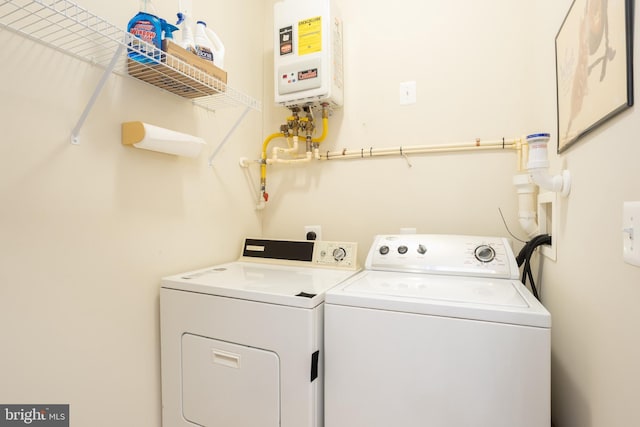 laundry area with laundry area, water heater, and separate washer and dryer