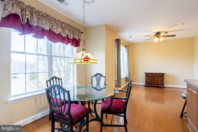 dining room with a wealth of natural light, visible vents, baseboards, and wood finished floors