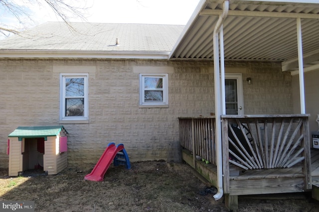 view of side of home with roof with shingles