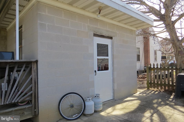 exterior space with concrete block siding and fence