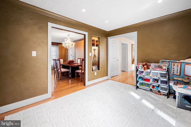 playroom with baseboards, ornamental molding, wood finished floors, a notable chandelier, and recessed lighting