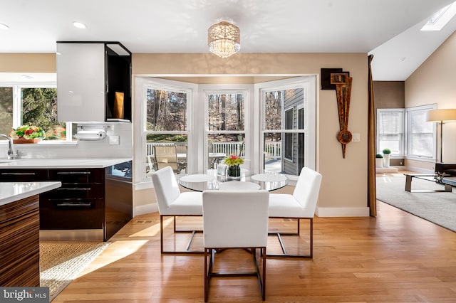 dining room with light wood finished floors, baseboards, an inviting chandelier, and recessed lighting