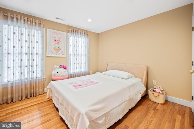 bedroom with recessed lighting, visible vents, baseboards, and wood finished floors